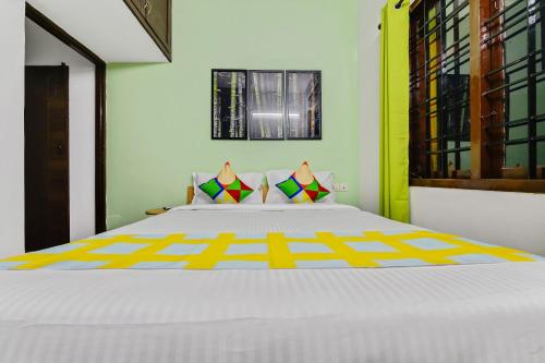 钦奈OYO Home G-cloud Near Thirumangalam Metro Station的卧室配有一张白色大床,拥有黄色色调