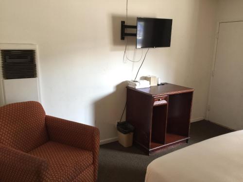 洛杉矶假日酒店的酒店客房设有椅子和电视。