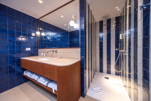 努马纳Murè Hotel Numana的蓝色瓷砖浴室设有水槽和淋浴