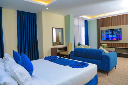 亚的斯亚贝巴Messay Hotel的酒店客房,配有床和蓝色的沙发