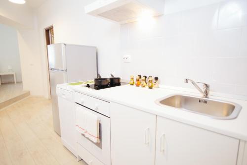 卡夫尼克超级滑雪高山公寓的白色的厨房配有水槽和冰箱
