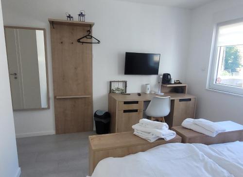 欧本Aparthouse HAAS41 - Eupen的一间卧室配有一张床和一张书桌及电视