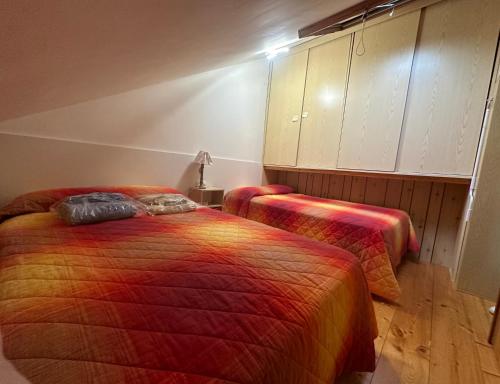 Albergo Monte RovereMini Appartamento Malga Laghetto的一间客房内配有两张床的房间