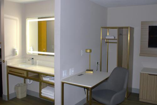 圣马科斯Baymont Inn & Suites by Wyndham San Marcos的一间带书桌、水槽和镜子的浴室