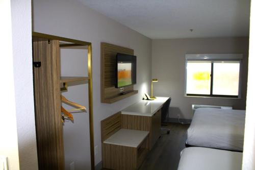 圣马科斯Baymont Inn & Suites by Wyndham San Marcos的一间卧室配有一张床、一张书桌和一台电视