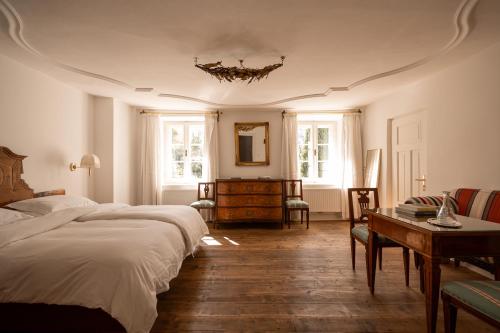 梅拉诺奥特曼古特套房及早餐酒店的一间卧室设有两张床、一张桌子和窗户。