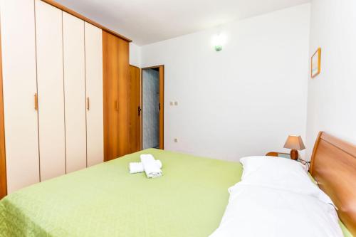 拉茨斯切Apartment Leo的一间卧室配有绿床和2条毛巾