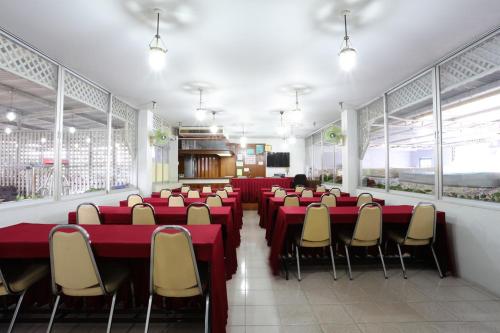 清迈Chomdoi House Hotel SHA Extra Plus的一间会议室,配有红色的桌子和椅子