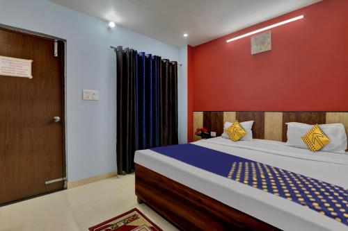 勒克瑙SPOT ON Hotel C S Tower的一间卧室设有一张床和红色的墙壁