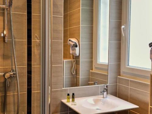圣马洛Hotel Le Croiseur Ginette Intra Muros的带淋浴、水槽和电话的浴室