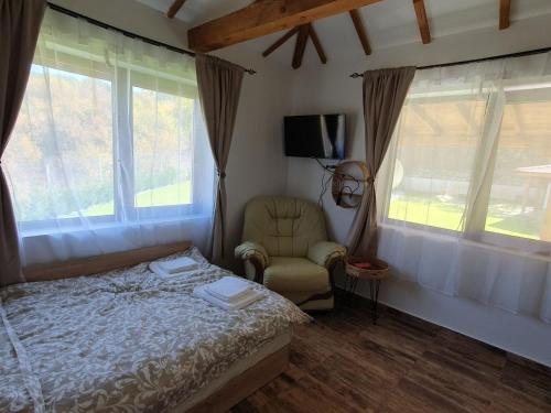 ElhovoVila agapi -Вила Любов的一间卧室配有一张床、一把椅子和窗户。
