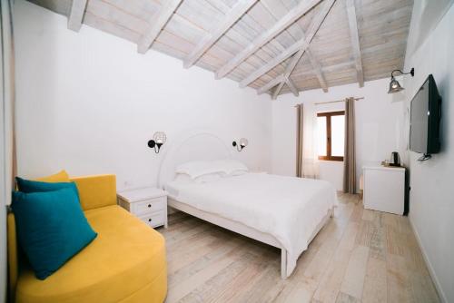 乌尔齐尼Hotel Pirate Old Town的白色卧室配有白色的床和黄色椅子