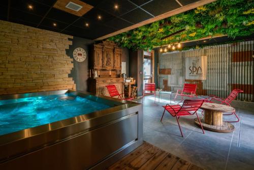 莱德萨阿尔卑斯Chamois Lodge的一个带红色椅子和桌子的房间的热水浴缸