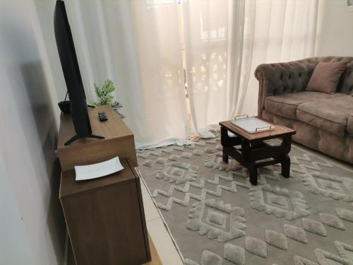 蒙巴萨Millan Homes的带沙发、电视和桌子的客厅
