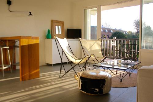 图尔热维尔克洛斯德萨比耶公寓 的客厅配有椅子、桌子和沙发