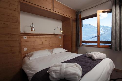 里蒙纽耶夏雷瓦隆峰温泉度假酒店的一间卧室设有一张床和一个享有山景的窗户。