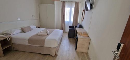 大加那利岛拉斯帕尔马斯Le Petit Palü Las Palmas的一间小卧室,配有一张床和一张书桌