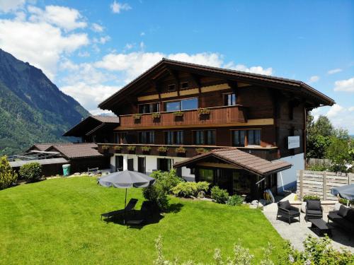 阿峙奇Bergblick Lodge - 3 Sterne Garni - Neueröffnung的一座大型木屋,前面设有绿色草坪