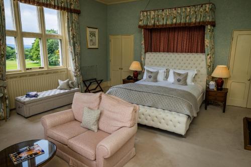 阿克菲尔德Horsted Place Hotel的一间卧室配有一张床、一张沙发和一把椅子