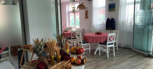 BasarabiTina Guest House的用餐室配有桌椅,提供水果和蔬菜