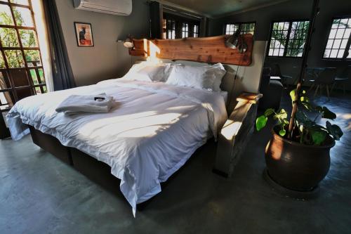 拉莫西Villa La Mercy Chalet No load shedding or water outages的一间卧室配有一张带白色床单的大床