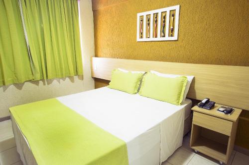 萨尔瓦多Rede Andrade Plaza Salvador的一间卧室配有一张带绿色床单的大床