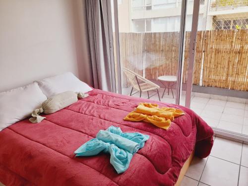 布宜诺斯艾利斯Turismo Aparts Urquiza的一间卧室配有红色的床和毛巾