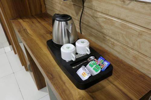 新德里Hotel Aurora Mirage Delhi的柜台上带咖啡壶的黑色托盘