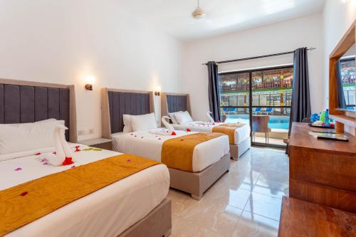 南威Canary Hotel & SPA的酒店客房设有三张床和电视。