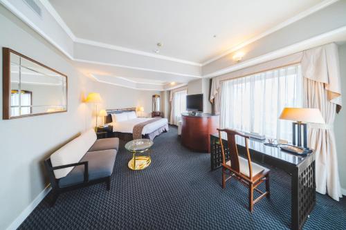 仓敷仓敷皇家艺术酒店的配有一张床和一张书桌的酒店客房