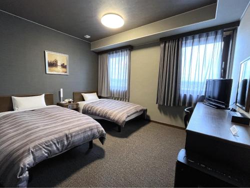 美浓加茂市美浓加茂罗特茵酒店的酒店客房设有两张床和一台平面电视。