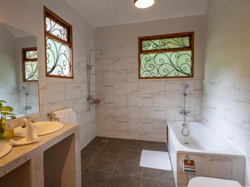阿鲁沙Mount Meru Game Lodge & Sanctuary的带浴缸和盥洗盆的浴室