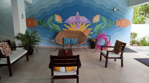 莫雷洛斯港Vela's Condos Ocean Front的一间带椅子的房间和壁画墙