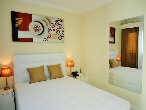 丰沙尔São Francisco Accommodation的卧室配有白色的床和镜子