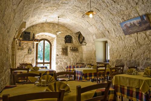 RoccamoriceAgriturismo Tholos的一间带桌椅和石墙的餐厅