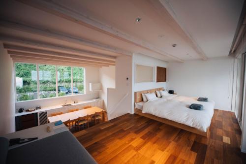 五岛Colorit GOTO ISLANDS的一间卧室配有一张床、一张书桌和一个窗户。