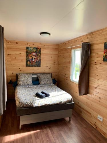 拉普兰德帕尔米斯特Chalet des capucines的木制客房内的一间卧室,配有一张床