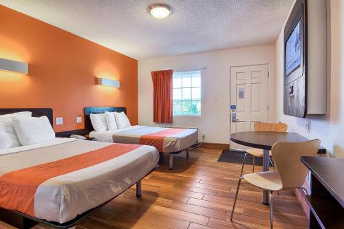 哈里森堡南哈里森6号汽车旅馆的酒店客房设有两张床和一张桌子。