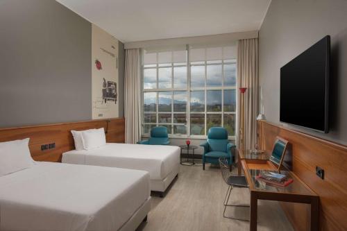 都灵灵格托都灵国会NH酒店的酒店客房设有两张床和一台平面电视。