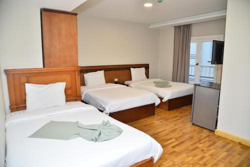 开罗Miramar Evergreen Hotel的酒店客房设有两张床和一台平面电视。