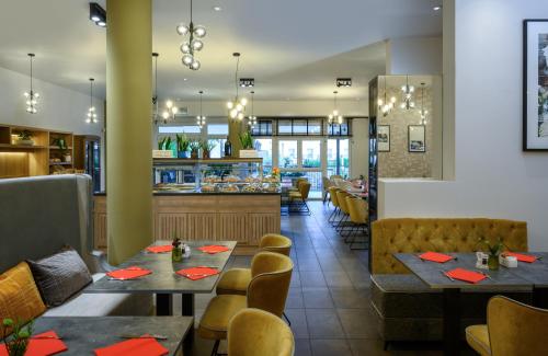 拉齐塞Leonardo Hotel Lago di Garda - Wellness and Spa的一间带桌椅的餐厅和一间酒吧