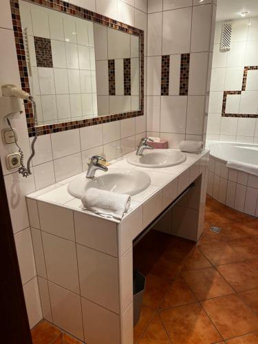 巴特贝特里希Vintagehotel Adler的一间带两个盥洗盆和大镜子的浴室