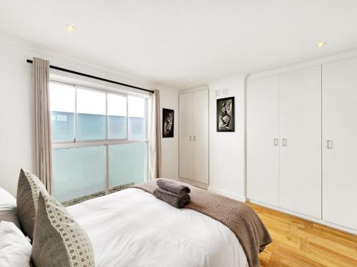 开普敦Urban Style House with Jacuzzi & Garage的一间卧室设有一张床和一个大窗户