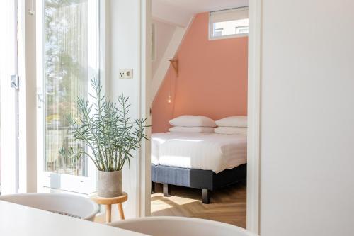 登博斯Achter de Kan的卧室里有一床,房间里还有植物