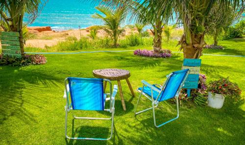 卡诺格布拉达Raio de Sol Residence的两把蓝色的椅子和一张桌子在草地上