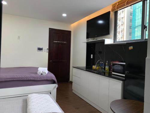 胡志明市LUCY HOTEL & APARTMENT的小房间设有床和厨房