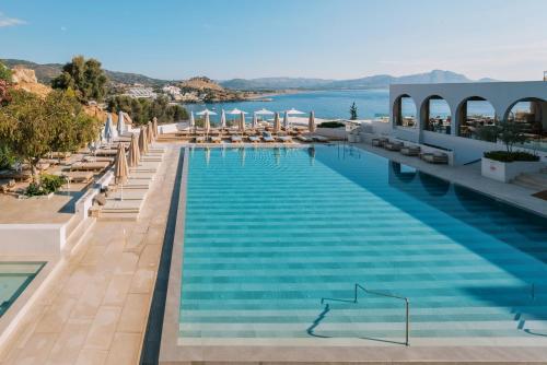 林都斯Lindos Mare, Seaside Hotel的一个带椅子和水的大型游泳池