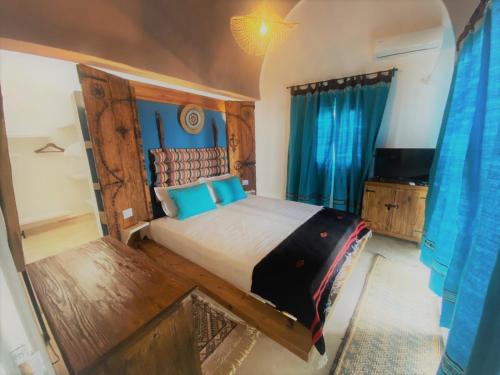 米多恩Hôtel Djerba Authentique - Au centre de Midoun的一间卧室配有一张大床和电视
