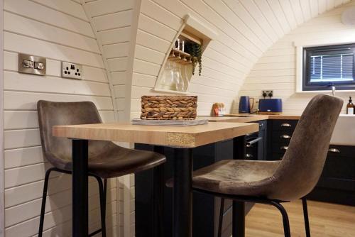 什鲁斯伯里EASTRIDGE GLAMPING的厨房配有桌子和两把椅子
