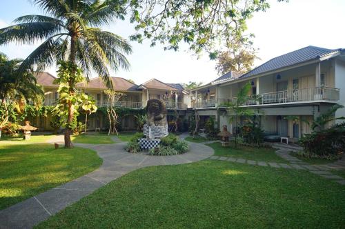 沙努尔萨伽拉田园酒店的棕榈树房子的庭院
